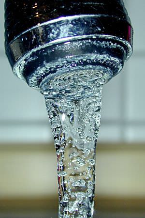Clean drinking water flowing from a faucet.
